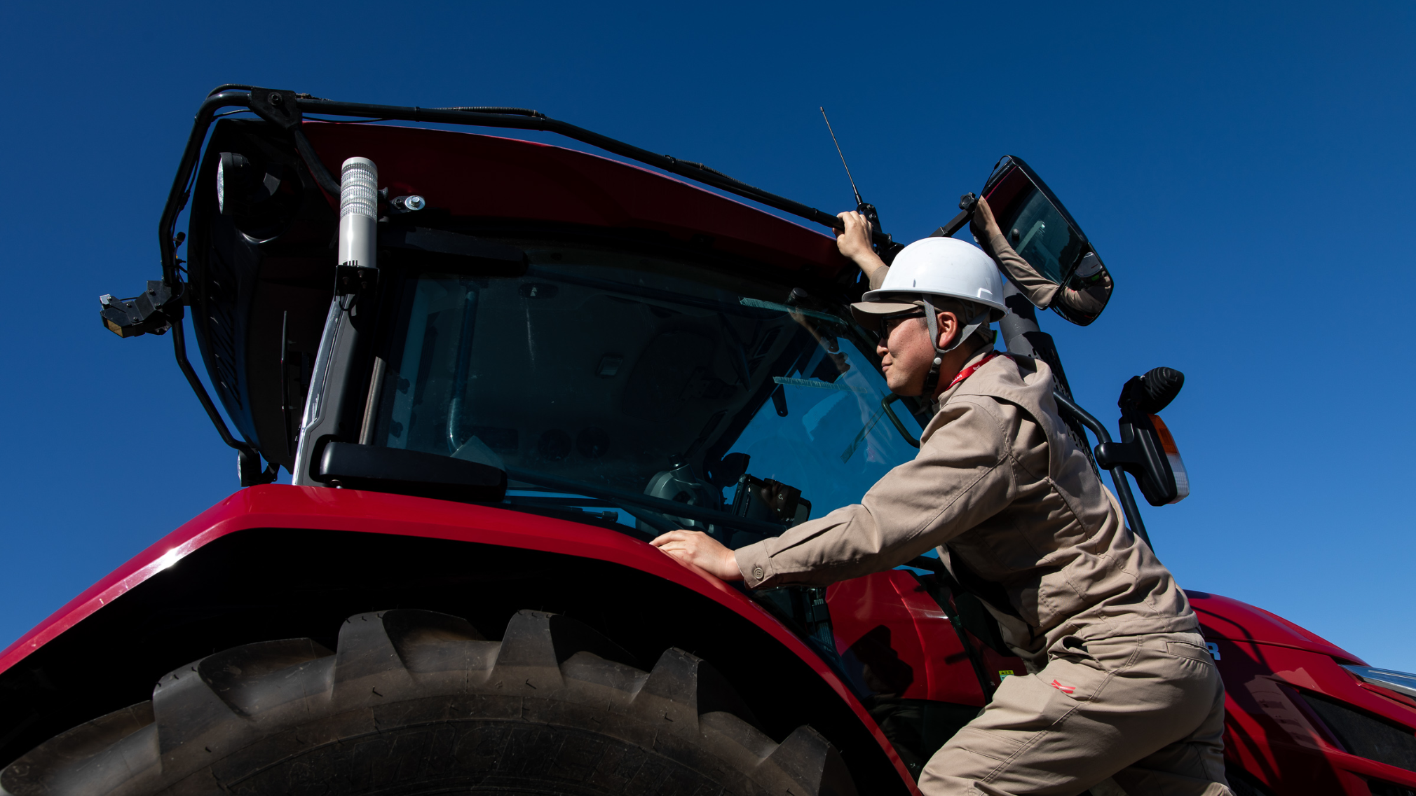 Un employé de Yanmar monte à bord d’un tracteur Yanmar utilisé pour l’agriculture moderne