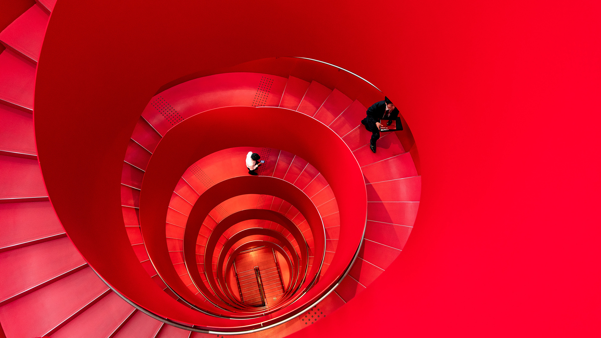 Des employés de Yanmar, entreprise de nouvelle technologie agricole, montent un escalier en colimaçon rouge