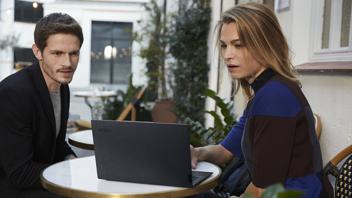 Two people looking at a Lenovo Yoga 9 screen in laptop mode