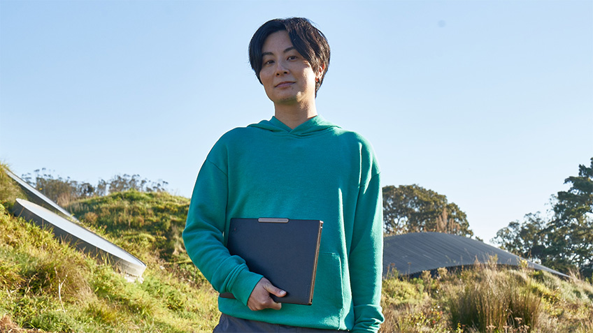 In forest holding laptop in one hand