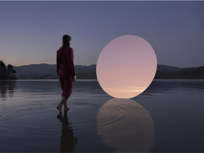 A human figure walks on water towards a circular portal.