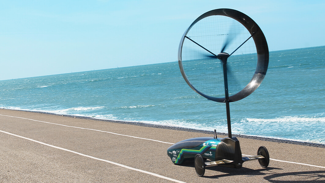 The wind-powered car designed by the Chinook engineering team drives by water