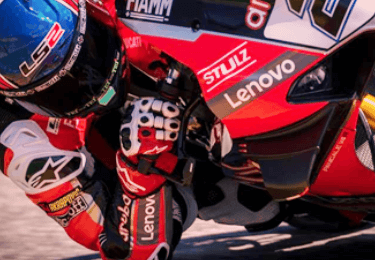 サーキットを疾走中のAruba.it Racing - Ducatiのスーパーバイクとライダーを上から見た画像。
