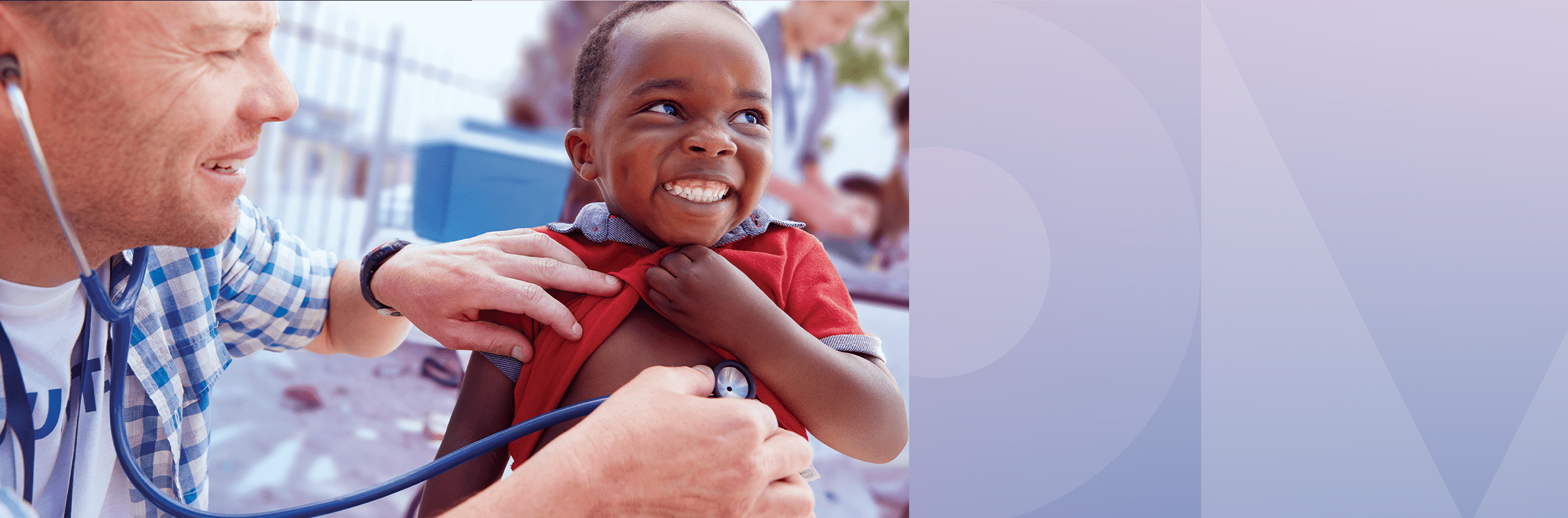 Un jeune enfant souriant par deux mains appliquant un stéthoscope sur la poitrine de l’enfant.