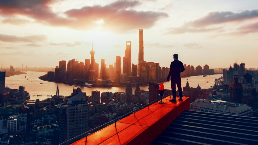 The silhouette of a human head and shoulders, surrounded by circular rings in shades of orange, with the bottom third of the image blurred into brown. 