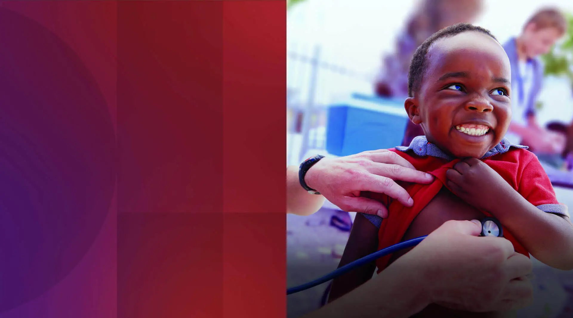 Un enfant noir dans une chemise rouge et bleue sourit joyeusement vers le haut à droite du cadre, comme une paire de mains adultes de la gauche vérifient son rythme cardiaque avec un stéthoscope.