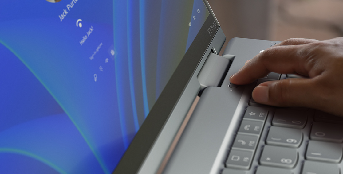 A finger shown activating the fingerprint reader integrated with the power button on the Lenovo ThinkPad X1 Yoga Gen 8 2-in-1 laptop.