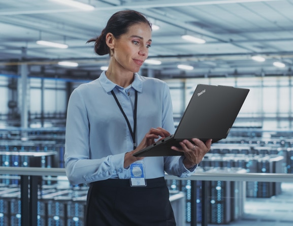 Person standing in data center, holding ThinkPad E14 Gen 5 (14