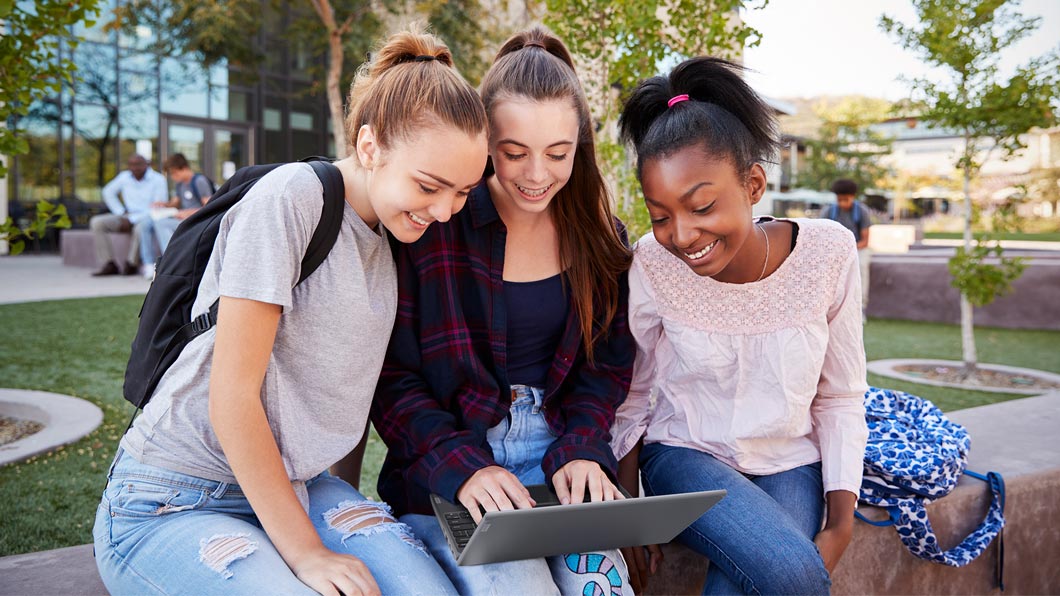 Lenovo 100e Windows laptop, being used by three female students.