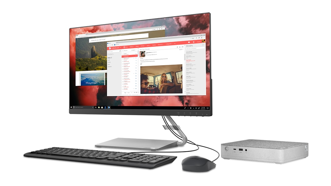 Billede set skråt fra højre af IdeaCentre Mini 5i-computeren til højre for en skærm, kabelforbundet tastatur og mus