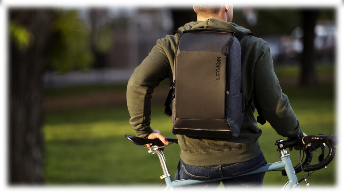 Shot of a young male on a bike, wearing a Lenovo Legion backpack