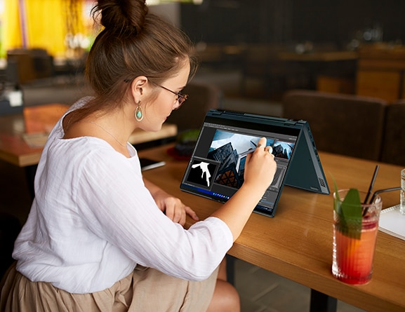 Imagen ilustrativa. Mujer con una Laptop 2-en-1 ThinkBook 14s Yoga 2da Gen en modo tienda con pantalla prendida