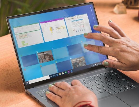 Nahaufnahme von zwei Händen mit grün lackierten Fingernägeln, die mit dem 33,8 cm (13,3'') Touchscreen eines Lenovo ThinkBook 13x Notebooks in Storm Gray interagieren.
