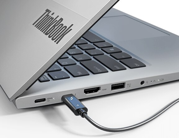Close-up of the ThinkBook 14 Gen 3 laptop’s left side, with the top cover open 45 degrees and showing the distinctive ThinkBook logo. The left-side ports are visible and the Thunderbolt™ 4 port is in use.