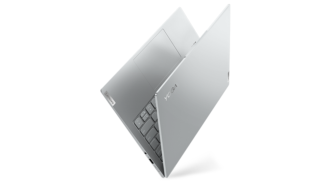 Left-side view of Yoga Slim 7 Pro Gen 7 (14″ AMD) laptop at an angle, partly opened in a V-shape, stood on one edge, showing top cover & part of keyboard
