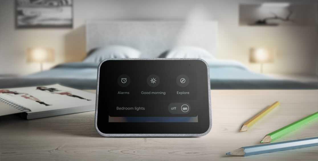 Lenovo Smart Clock with the Google Assistant on a nightstand, showing the bedroom lights being turned on.