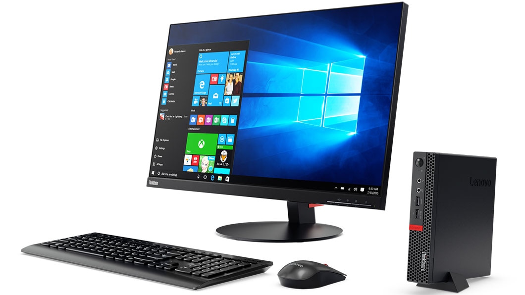ThinkCentre M910x Tiny positioned vertically in stand, next to monitor, keyboard, and mouse.