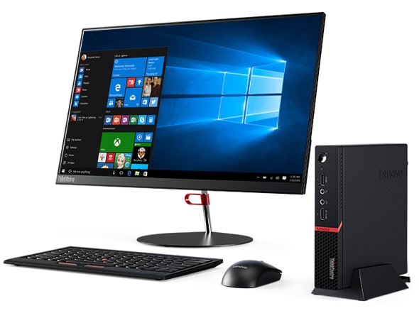 Lenovo ThinkCentre M715q Tiny desktop positioned vertically, alongside monitor, keyboard, and mouse.
