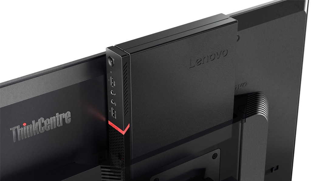 Primeiro plano do Lenovo ThinkCentre M715q Tiny colocado atrás de um monitor para realçar o tamanho pequeno