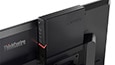 Close up shot of Lenovo ThinkCentre M715q Tiny positioned behind a monitor highlighting the tiny size thumbnail