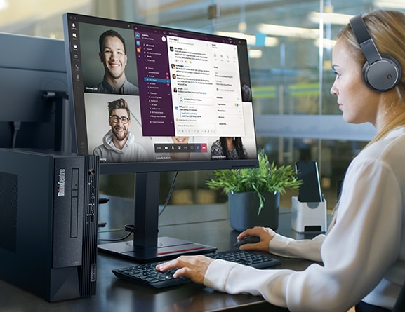 A person sits at an office desk, facing left, while using a ThinkCentre Neo 50s Gen 4 SFF business PC for a conference call (monitor & headset not included).