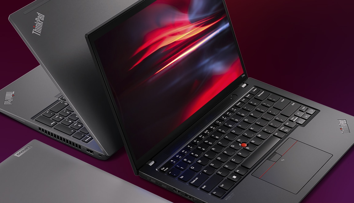 Back-to-back Lenovo ThinkPad T Series laptops, black facing forward & silver facing backward.