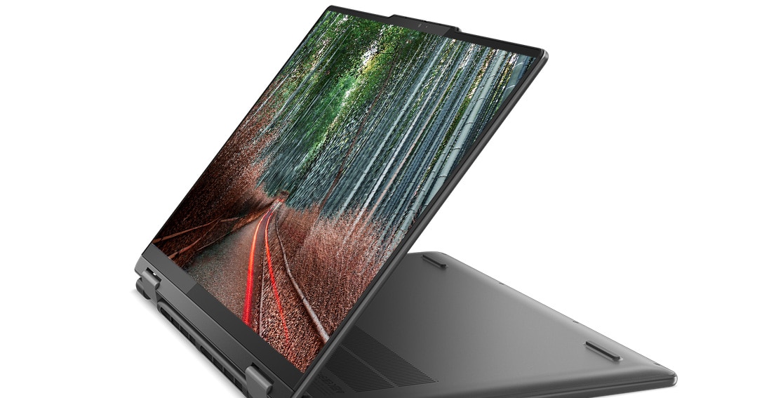 Angle view of the Lenovo Yoga 7 Gen 8 (14” AMD) 2-in-1 laptop in stand mode, with an image of a forest road on the display